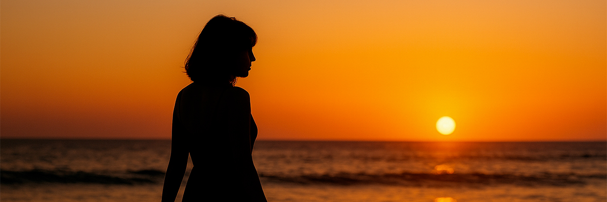Une femme face à un coucher de soleil sur une plage